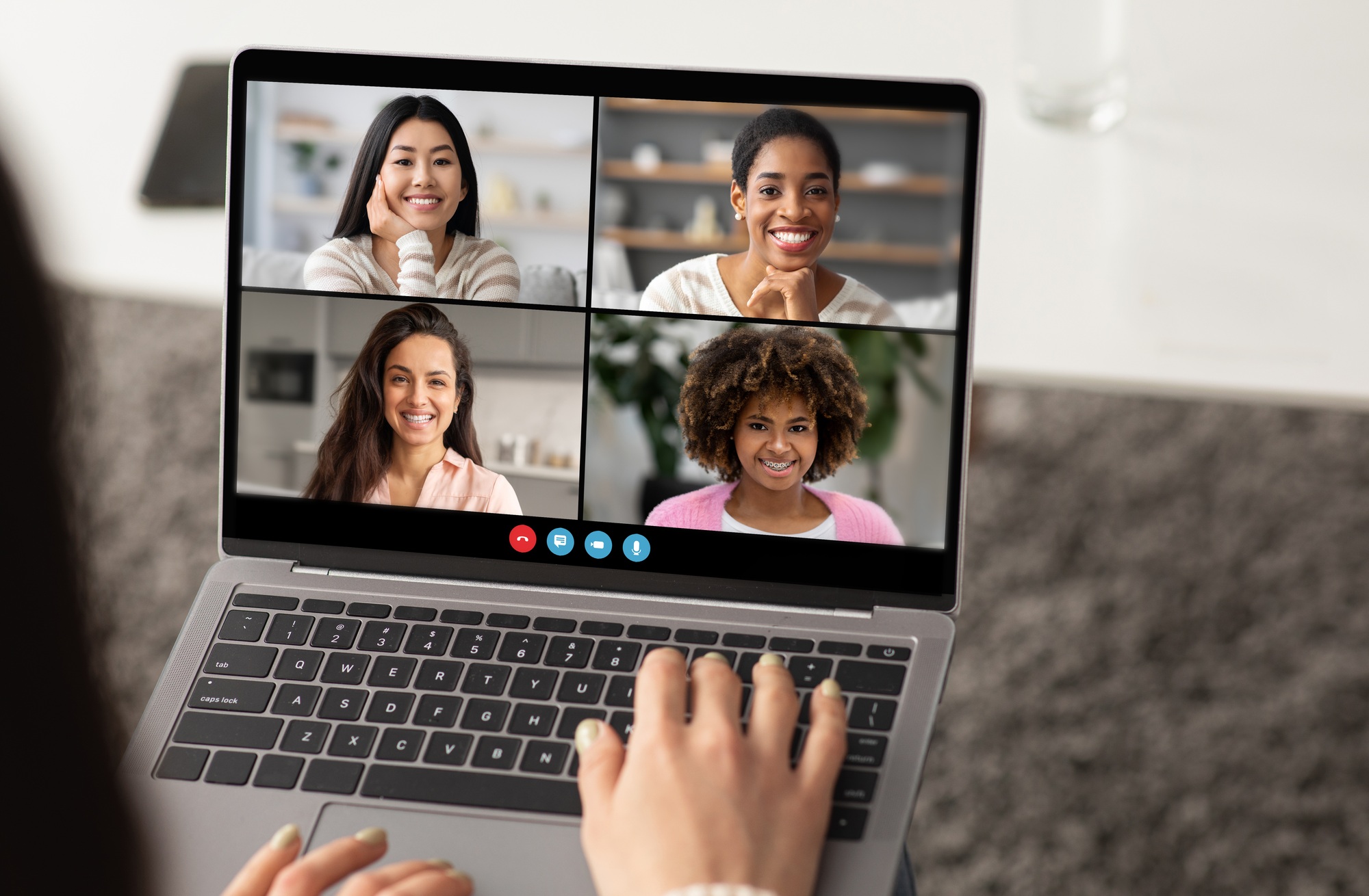 Women engaged in a virtual meeting on a laptop during the day